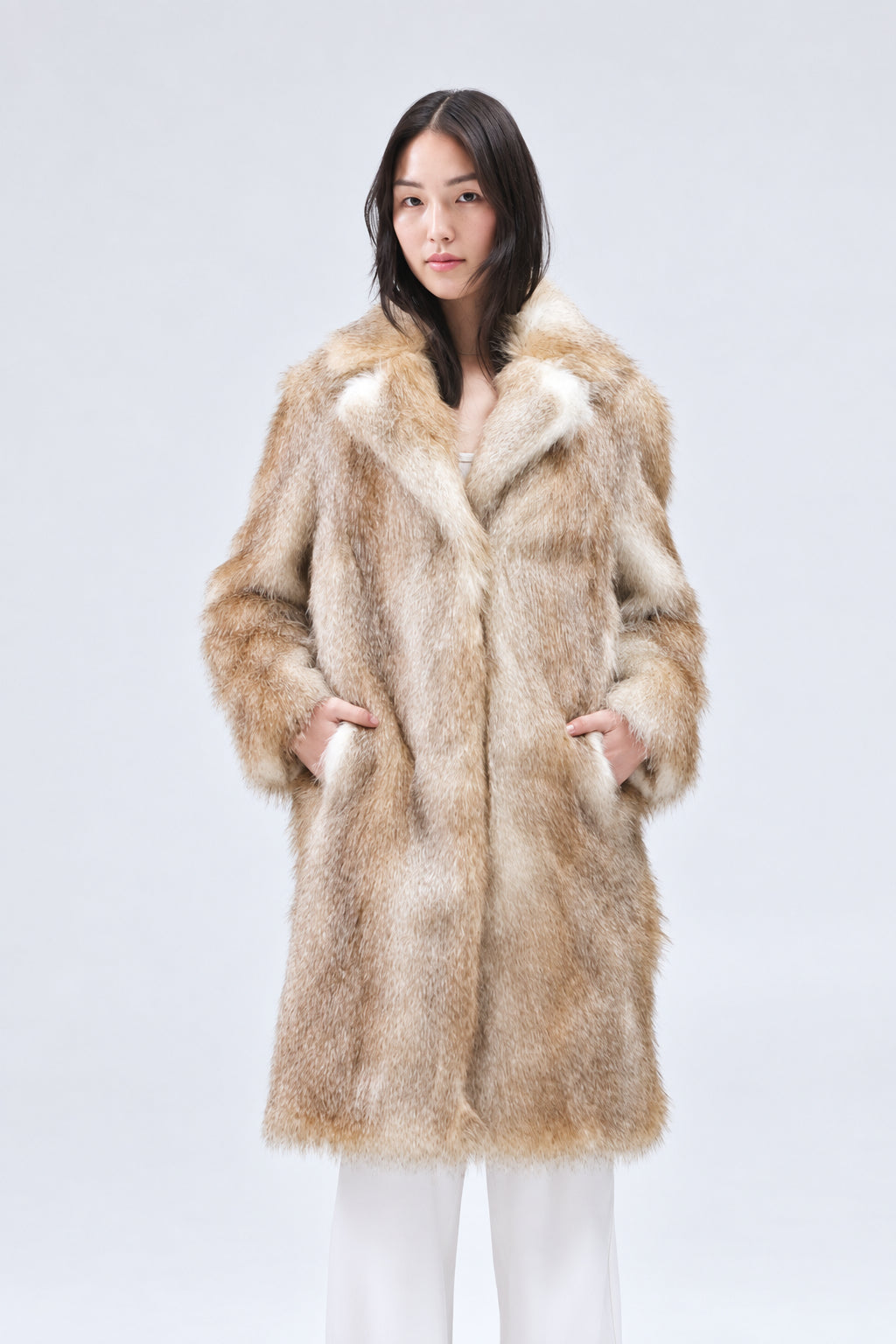 Person wearing a fur coat against a plain background